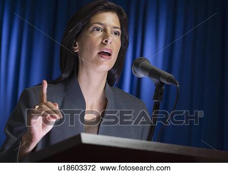 Stock Image - Close up of businesswoman speaking at podium. Fotosearch