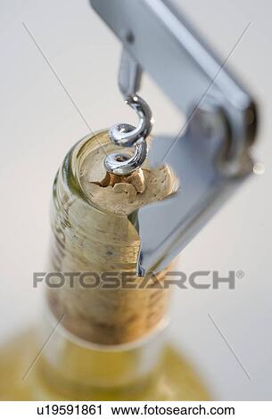Stock Image - Close up of corkscrew in wine bottle. Fotosearch