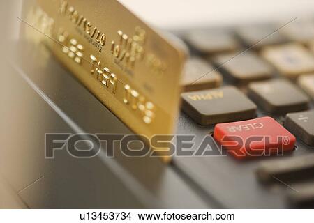 Picture - Close up of credit card machine and credit card. Fotosearch