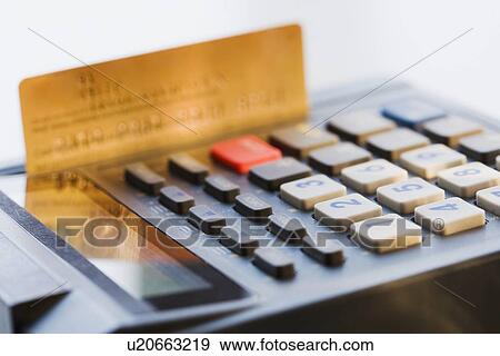 Stock Photo - Close up of credit card machine and credit card. Fotosearch