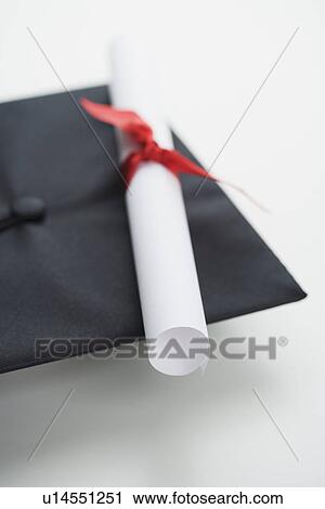 Stock Image - Close up of diploma and graduation cap. Fotosearch