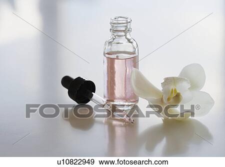 Stock Photo - Close up of flower and bottle of oil. Fotosearch