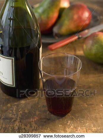 Stock Photo - Close up of glass of wine and wine bottle. Fotosearch