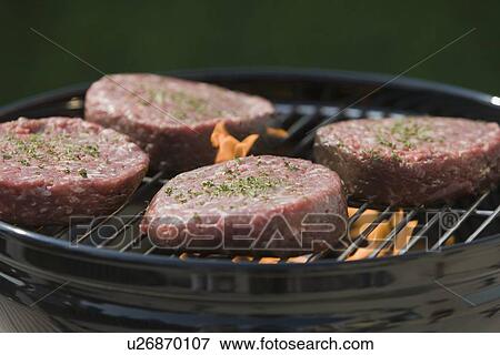 Stock Photo - Close up of hamburgers on barbecue grill. Fotosearch
