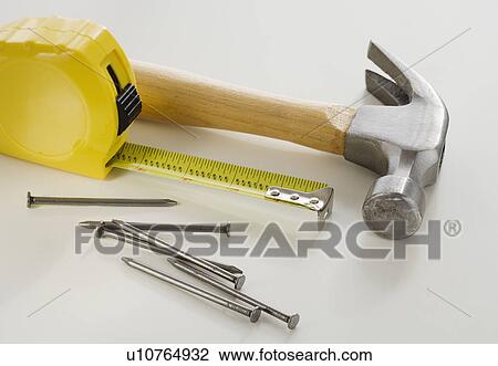 Stock Image - Close up of hammer, nails and tape measure. Fotosearch