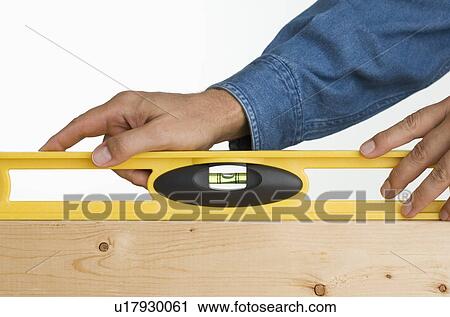 Close up of man using level on piece of wood View Large Photo Image Stock Image - Close up of man using level on piece of wood. Fotosearch