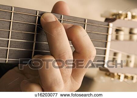 Stock Photo - Close up of man's hand playing guitar. Fotosearch