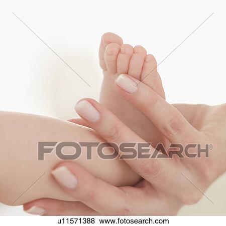 Close up of mother holding baby's foot View Large Photo Image Stock Photo - Close up of mother holding baby's foot. Fotosearch