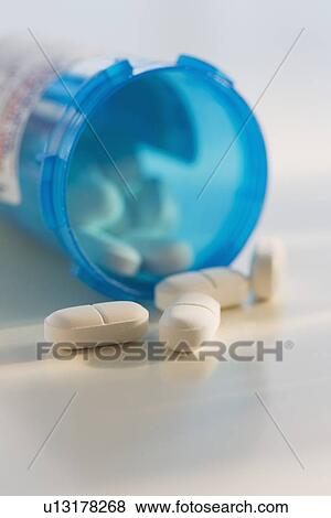 Stock Photo - Close up of pills spilling out of bottle. Fotosearch