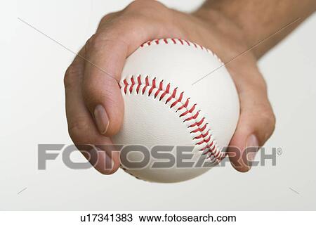 Stock Image - Close up of pitcher holding baseball. Fotosearch