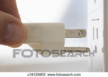 Stock Image - Close up of plug next to outlet. Fotosearch