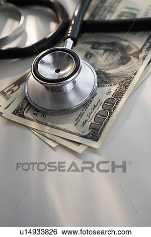 Close up of stethoscope and US dollars View Large Photo Image Stock Photograph - Close up of stethoscope and US dollars. Fotosearch