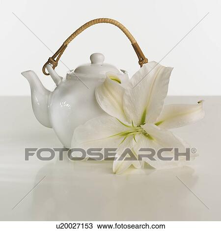 Stock Image - Close up of teapot and flower. Fotosearch