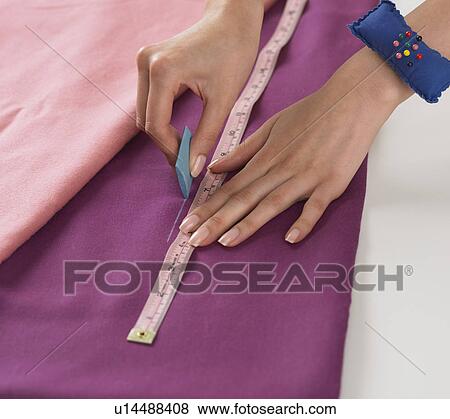 Stock Photo - Close up of woman cutting fabric. Fotosearch