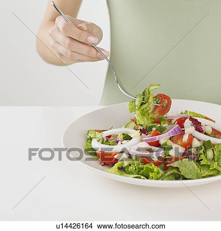 Close up of woman eating plate of salad View Large Photo Image Picture - Close up of woman eating plate of salad. Fotosearch