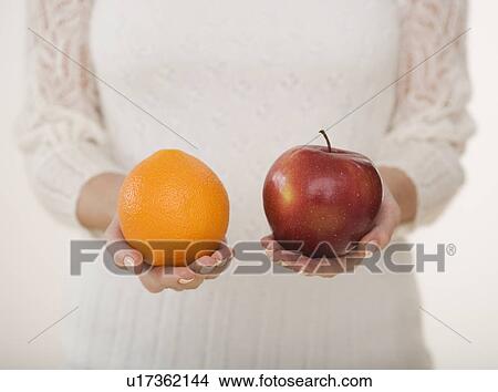 Close up of woman holding apple and orange View Large Photo Image Picture - Close up of woman holding apple and orange. Fotosearch