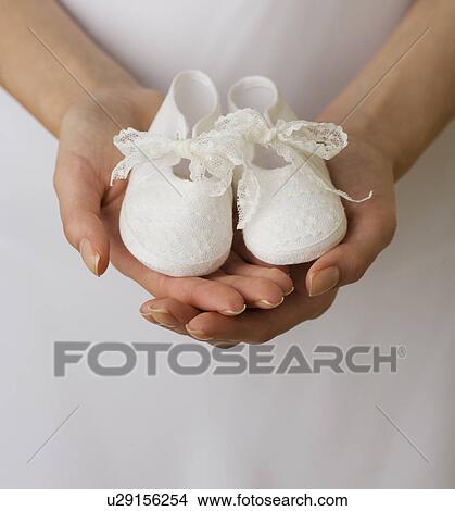 Close up of woman holding baby shoes View Large Photo Image Picture - Close up of woman holding baby shoes. Fotosearch
