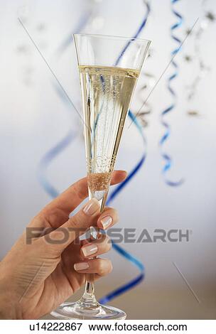 Stock Photo - Close up of woman holding champagne flute. Fotosearch