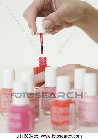 Stock Photography - Close up of woman opening nail polish. Fotosearch