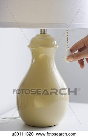 Close up of woman pulling chain on lamp View Large Photo Image Stock Image - Close up of woman pulling chain on lamp. Fotosearch