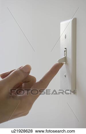 Stock Photo - Close up of woman turning on light switch. Fotosearch