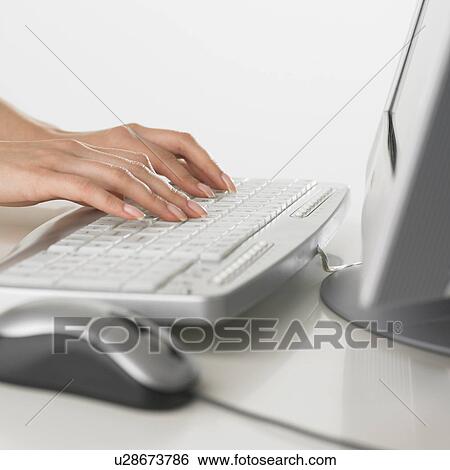 Stock Photograph - Close up of woman typing on computer keyboard. Fotosearch