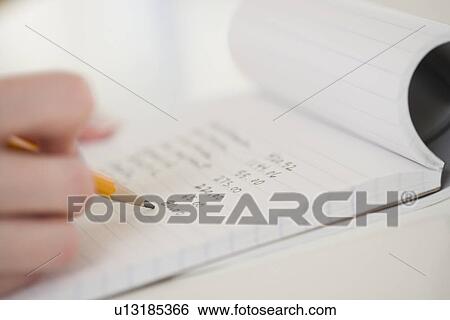 Stock Photograph - Close up of woman writing in notebook. Fotosearch