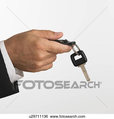 Close up studio shot of man holding car keys View Large Photo Image Stock Photograph - Close up studio shot of man holding car keys. Fotosearch