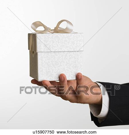 Close up studio shot of man holding gift View Large Photo Image Stock Image - Close up studio shot of man holding gift. Fotosearch