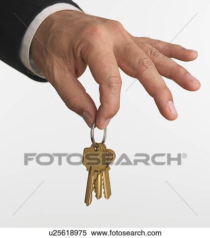 Stock Photography - Close up studio shot of man holding set of keys. Fotosearch