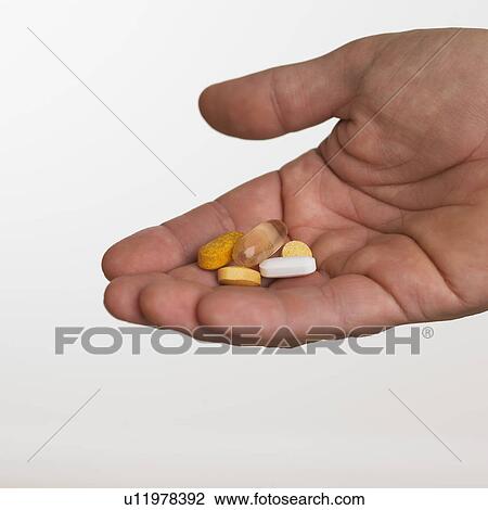 Close up studio shot of man holding vitamins View Large Photo Image Stock Image - Close up studio shot of man holding vitamins. Fotosearch