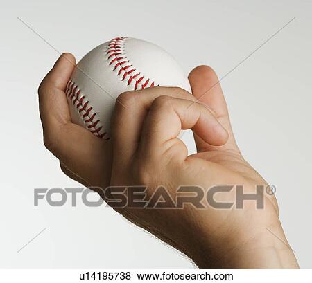 Stock Photo - Close up studio shot of man holding baseball. Fotosearch
