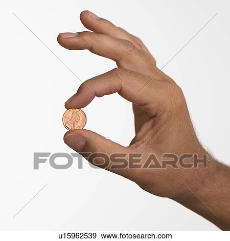 Stock Photo - Close up studio shot of man holding penny. Fotosearch