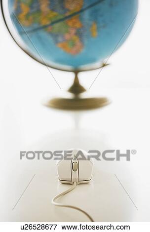 Computer mouse in front of globe View Large Photo Image Stock Photo - Computer mouse in front of globe. Fotosearch
