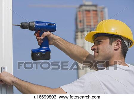 Construction worker using cordless drill View Large Photo Image Stock Image - Construction worker using cordless drill. Fotosearch