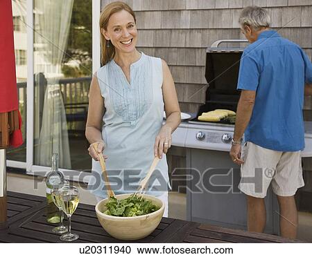 Couple barbecuing on deck View Large Photo Image Stock Image - Couple barbecuing on deck. Fotosearch