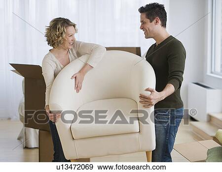 Stock Photo - Couple carrying armchair. Fotosearch