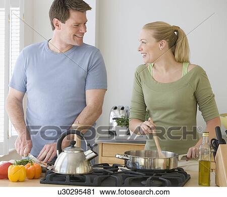 Stock Image - Couple cooking in kitchen. Fotosearch