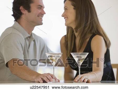 Stock Image - Couple drinking martinis. Fotosearch