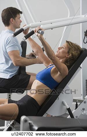 Stock Image - Couple exercising at gym. Fotosearch