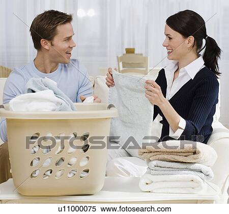 Couple folding laundry in livingroom View Large Photo Image Stock Photography - Couple folding laundry in livingroom. Fotosearch
