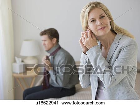 Stock Image - Couple getting dressed. Fotosearch