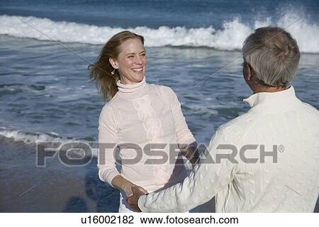 Couple holding hands at beach View Large Photo Image Stock Image - Couple holding hands at beach. Fotosearch
