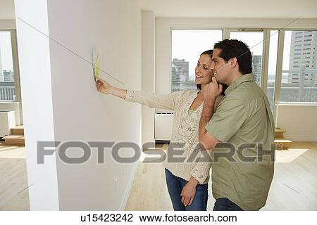 Couple holding paint swatches up to wall View Large Photo Image Stock Image - Couple holding paint swatches up to wall. Fotosearch