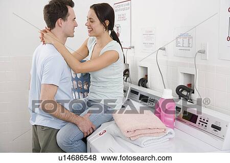Couple hugging in laundry room View Large Photo Image Stock Photo - Couple hugging in laundry room. Fotosearch