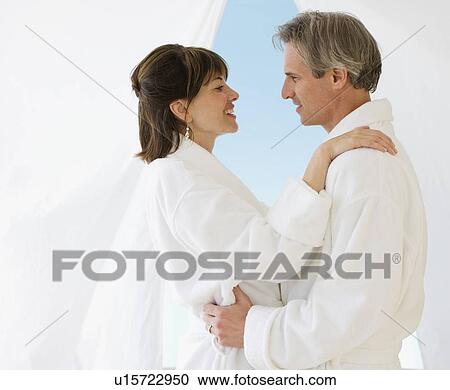 Stock Image - Couple in bathrobes hugging. Fotosearch