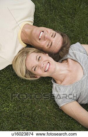 Picture - Couple laying in grass. Fotosearch