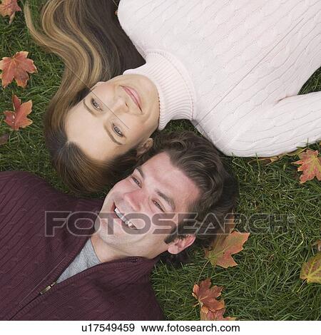 Couple laying in grass View Large Photo Image Stock Photo - Couple laying in grass. Fotosearch