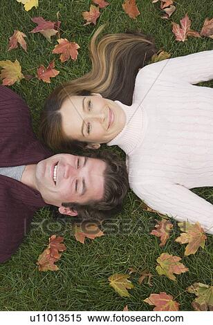 Stock Photography - Couple laying in grass. Fotosearch