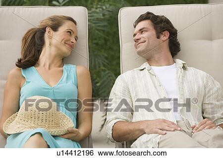 Stock Photograph - Couple laying in lounge chairs. Fotosearch